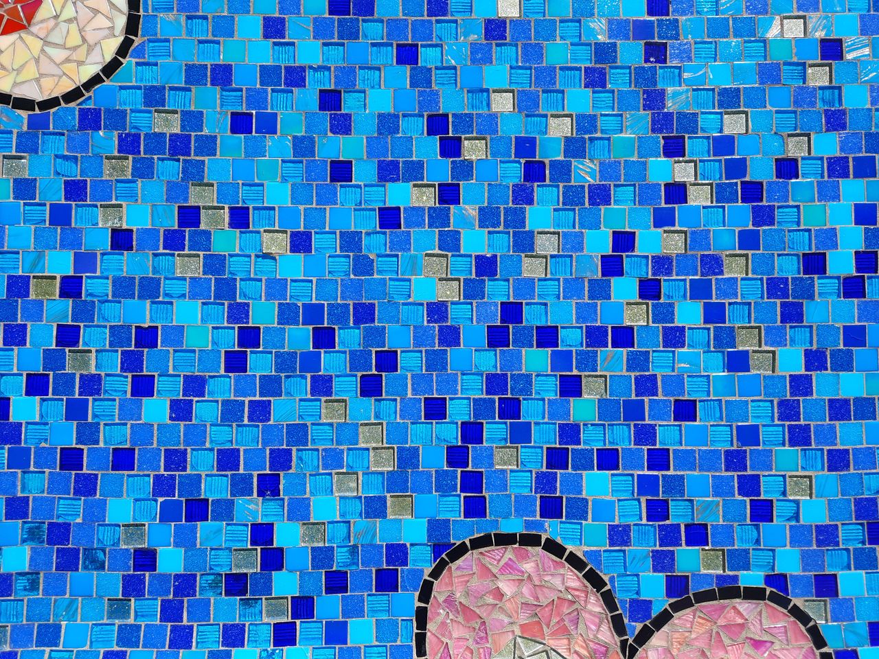 A colorful mosaic tile wall with various shades of blue creating a vibrant pattern.
